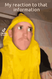a man in a banana costume is making a funny face while wearing a yellow beanie .