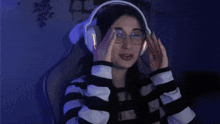 a woman wearing headphones giving a thumbs up