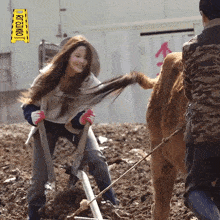 a woman is standing in the dirt with a yellow sign that says kyojung on it