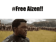 a black man stands in front of a crowd of people and says #free aizen !!