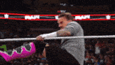 a man in a wrestling ring with the word raw on the screen