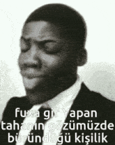a black and white photo of a man in a suit and tie making a funny face with his eyes closed .