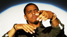 a man wearing a gold bracelet is making a funny face with his hands