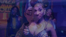 a woman in a purple dress is standing in front of a group of women