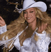 a woman wearing a white cowboy hat and a white jacket .