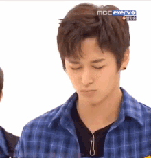a young man wearing a blue plaid shirt is on a mbc everyo show
