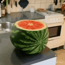 a watermelon has been cut in half and is sitting on a kitchen counter