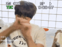 a video of a man covering his mouth with a tbc logo in green