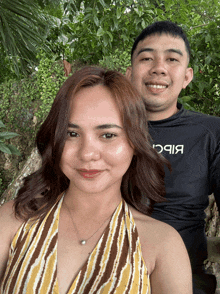 a man and a woman are posing for a picture and the man is wearing a black shirt that says bbc