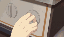 a hand is pressing a button on a stove that has the number 1 on it