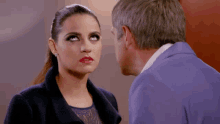 a man and a woman are looking at each other and the woman has red lips