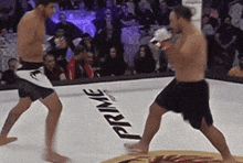 two men are fighting in a boxing ring with the word prime on the floor