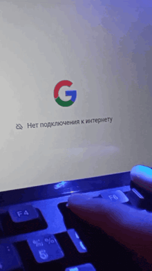 a person is typing on a laptop with a g on the screen