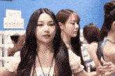 a woman with long hair is standing in front of a sign that says ' a ' on it
