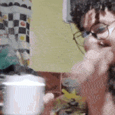 a man wearing glasses is holding a cup of coffee in his hand .