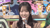 a woman is smiling while holding a fork and eating food