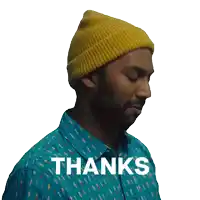 a man wearing a yellow beanie and a blue shirt says " thanks "