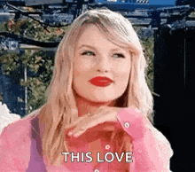 a woman with blonde hair and red lipstick is wearing a pink shirt and saying `` this love '' .