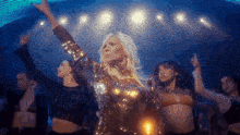 a woman in a sequined dress is dancing on stage
