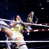 a woman in a wrestling ring holds a belt that says ' smackdown ' on it