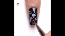 a person is applying nail polish to their nails and painting a design on them .