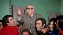 a man in a suit and tie is pointing at something