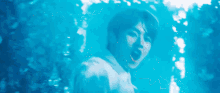 a man in a white shirt is swimming in a blue pool