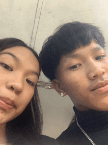 a boy and a girl pose for a picture together