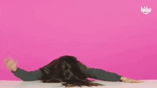 a woman laying on her back making a i love you sign with her hands