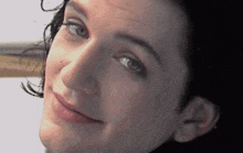 a close up of a woman 's face with blue eyes and black hair