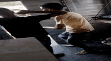 a man in a yellow shirt is standing on a concrete floor