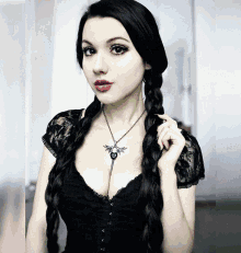 a woman wearing a black lace top and a necklace with a dragon on it
