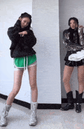 two women standing next to each other wearing shorts