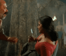 a woman in a red top is holding a bottle