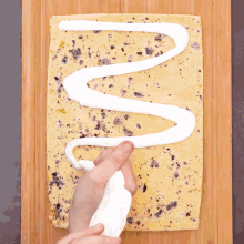 a person is spreading frosting on a piece of food