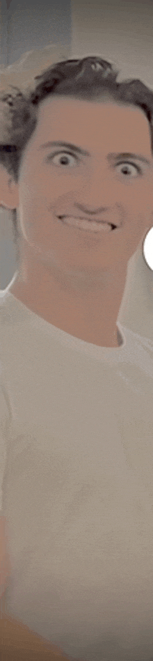 a man in a white shirt is smiling and making a funny face