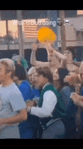 a crowd of people are dancing in front of an american flag and a sign that says what is blud doing .