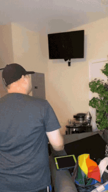 a man in a black hat stands in front of a tv