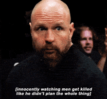 a bald man with a beard is watching men get killed like he did n't plan the whole thing