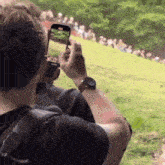 a man taking a picture of a group of people on a hill