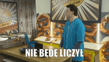 a man in a blue shirt is standing in front of a bakery counter with a sign that says " nie bede liczyl "