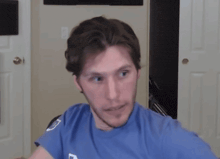 a man wearing a blue shirt with the letter l on it