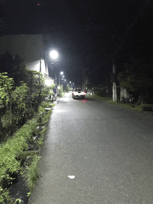 a red suv is parked on the side of a road at night