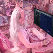 a girl wearing pink headphones sits in front of a computer with a poster on the wall that says dead man 's chest