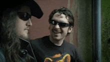 a man wearing sunglasses and a black shirt with a picture of a snake on it