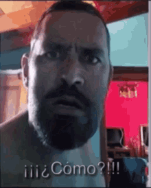 a man with a beard is making a funny face while talking to someone .