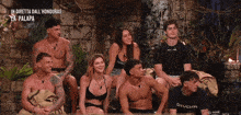 a group of people are sitting in front of a sign that says in diretta dall ' honduras la palapa