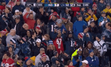 a crowd of people watching a football game with a score of 7 to 7