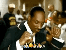 a man in a suit is holding a fork in his mouth and the words yeah baby are above him