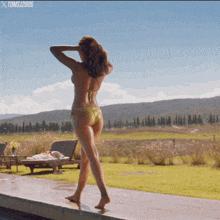 a woman in a bikini is standing on a ledge with toms / 2005 written on the bottom